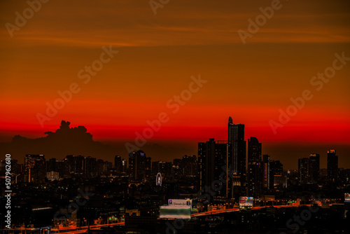 The high angle background of the city view with the secret light of the evening, blurring of night lights, showing the distribution of condominiums, dense homes in the capital community