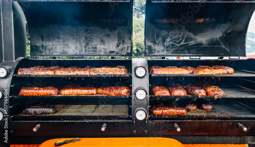 Fotografija Large barbecue smoker grill with grilled meat wrapped with bacon