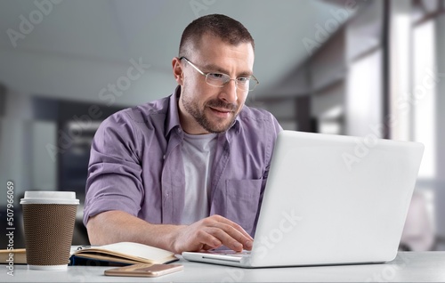 American Businessman Drinking Coffee Using Laptop Computer Sitting During Break