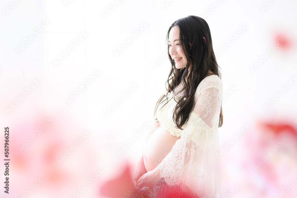 花に囲まれた美しい女性のマタニティフォト ピンクのかわいい前ボケあり 花に囲まれた美しい女性のマタニティフォト ピンクのかわいい前ボケあり
