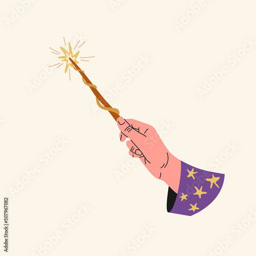 The hand of a person holds a magic wand. The hand of a fairy-tale character.