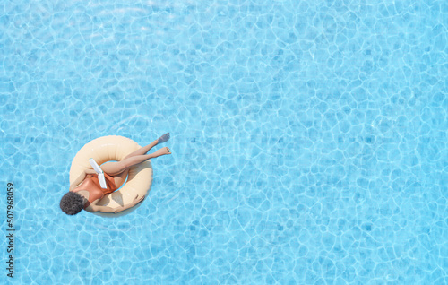 woman floating in swimming pool and reading book #507968059