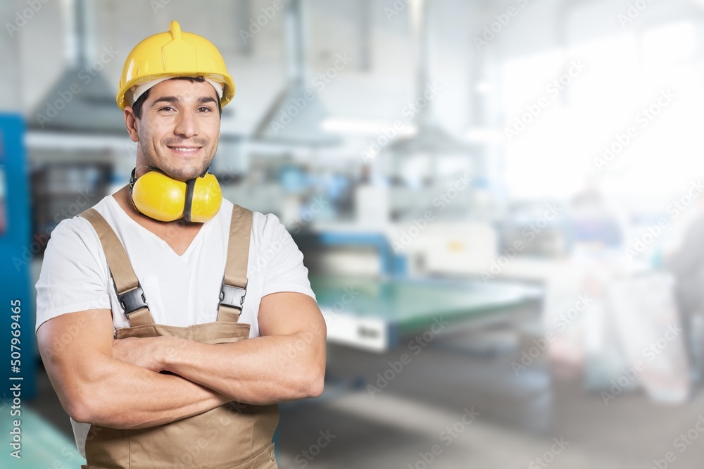 A man workers engineering standing with safety helmet in front of indoor factory. Concept of smart industry worker operating. A man workers engineering standing with safety helmet in front of indoor factory. Concept of smart industry worker operating.