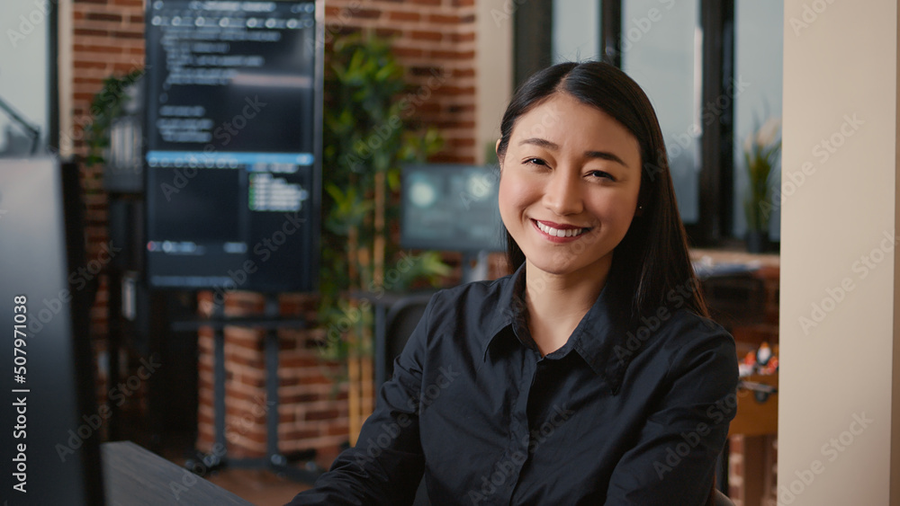Fototapeta premium Smiling software developer typing machine learning app code on computer keyboard sitting at desk in big data office. Friendly cloud programer working casually in cyber security agency.
