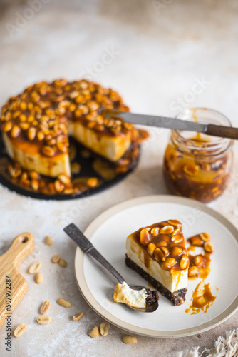 homemade cheesecake with peanuts and caramel on a light background