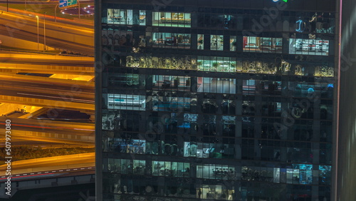 Outside view of windows in offices of a high class building at night timelapse