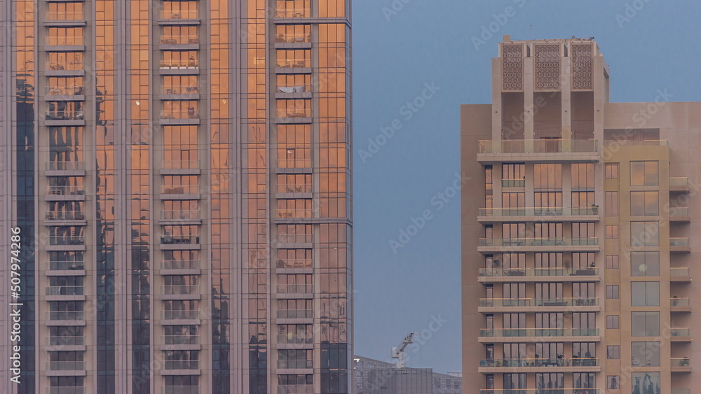 Naklejka premium Skyscrapers with stunning sun reflections on the teal and orange glass facades, with blue sky timelapse
