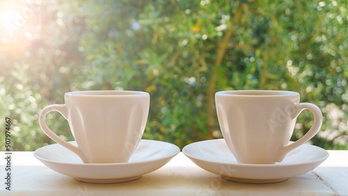 Two cup of coffee or brewed Turkish tea on green nature background. Drinking coffee to start a day positive mood or stay awake, sleepless. Coffee (espresso, americano etc.) addiction concept.