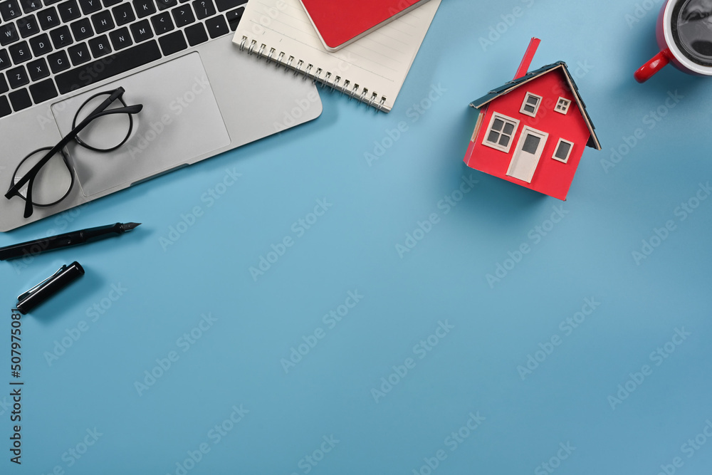 Laptop computer, glasses, notepad and house model on lea background. Real estate investors, insurance and maintenance concept - obrazy, fototapety, plakaty 