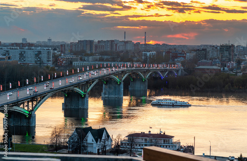 High resolution panorama. Kanavinsky Bridge Nizhny Novgorod at sunset in spring. Reflection of the sunset in the water, pleasure boat photo