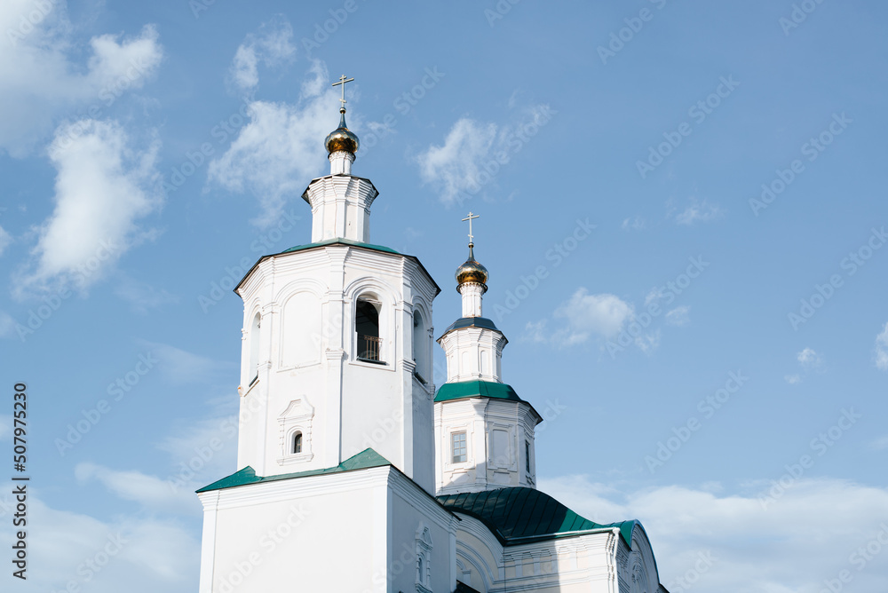 Close-up religious architecture of Middle Ages. Ancient white church, old monastery facade against blue sky outdoors
