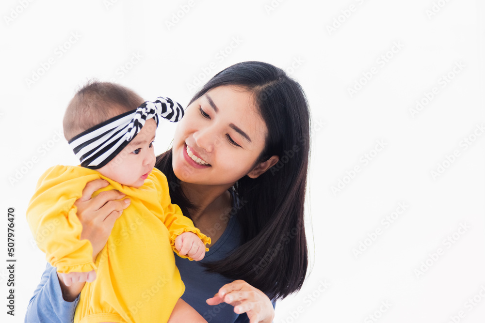 Portrait of beautiful young Asian mother playing and smiling together with his newborn little baby at home, Parent mom and little kid relaxing in the bedroom, Family having fun together Portrait of beautiful young Asian mother playing and smiling together with his newborn little baby at home, Parent mom and little kid relaxing in the bedroom, Family having fun together