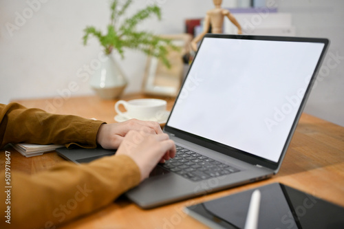 Close-up female freelancer using laptop computer  typing on keyboard  doing her online work