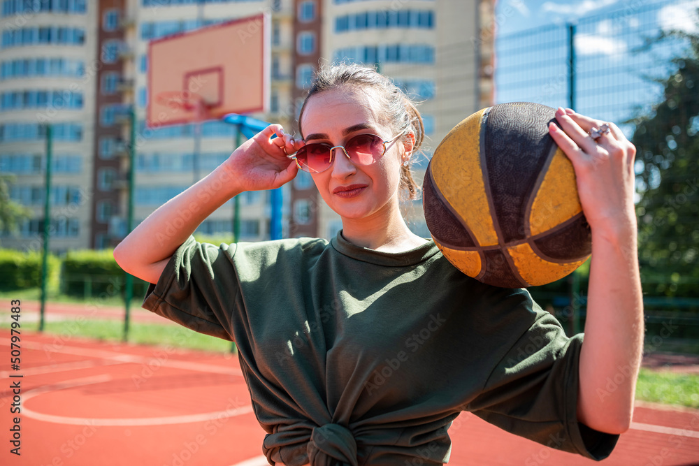 Young woman hold basketball on basketball court