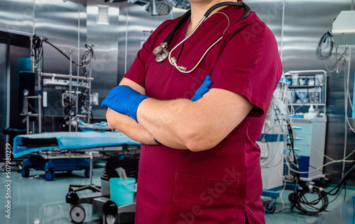 doctor or nurse in red uniform with stethoscope staning at emergency room photo