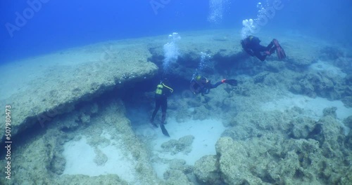Wallpaper Mural  scuba diver exploring around a reef underwater deep blue water big rocks and bubbles ocean scenery  Torontodigital.ca