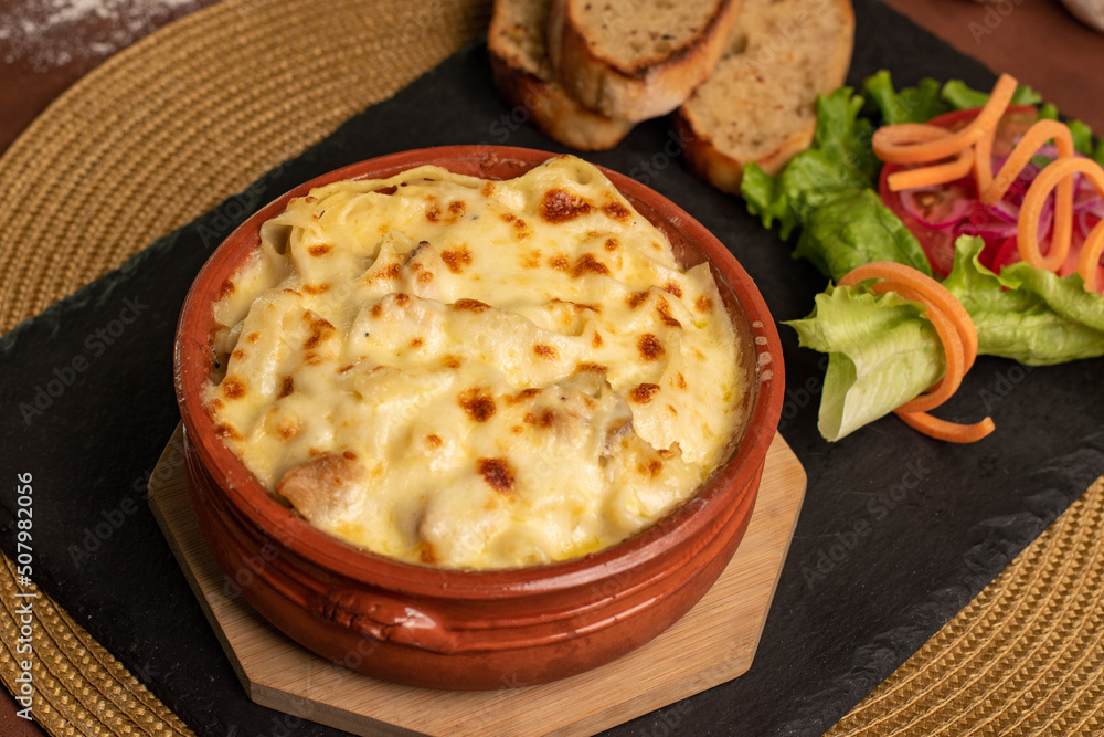 Bowl of Melted cheese served with salad and bread Bowl of Melted cheese served with salad and bread