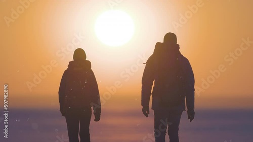 The two backpackers walking on the sunset background. slow motion