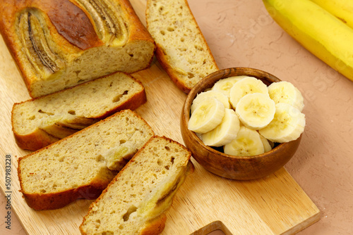 Fototapeta Naklejka Na Ścianę i Meble -  Baked banana bread, sliced on a cutting board. Bakery, cafe, home chef, menu concept