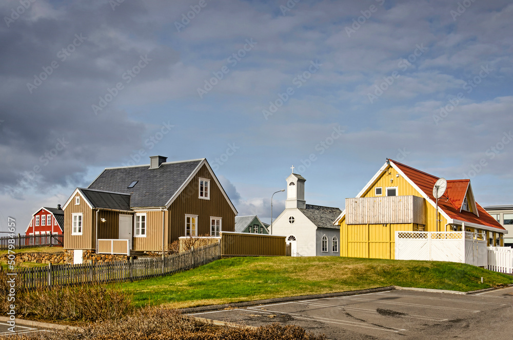 Stykkisholmur, Iceland, May 3, 2022: traditional houses and church in the heart of town, illuminated by the evening sun