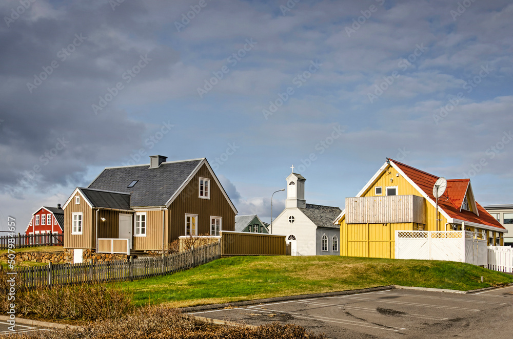 Stykkisholmur, Iceland, May 3, 2022: traditional houses and church in the heart of town, illuminated by the evening sun Stykkisholmur, Iceland, May 3, 2022: traditional houses and church in the heart of town, illuminated by the evening sun