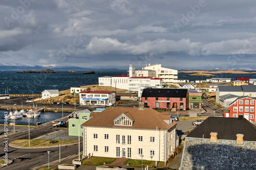 Stykkisholmur, Iceland, May 3, 2022: evening sun illuminates houses, the hospital and other buildings around the harbour