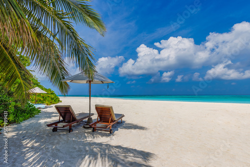 Tropical beach nature as summer landscape with lounge chairs and palm trees and calm sea for beach banner. Luxury travel landscape  beautiful destination for vacation or holiday. Couple beach scenic