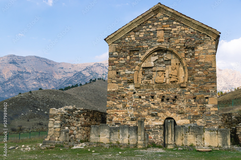An ancient stone temple high in the mountains. Place of religious ceremonies. The old church on the background of the mountains. History and memory immortalized in stone.