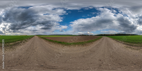full seamless spherical hdri 360 panorama view on no traffic gravel road among fields in summer day with awesome clouds in overcast sky in equirectangular projection, ready for VR AR