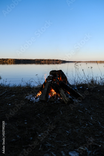 bonfire on the shore of the lake summer evening
