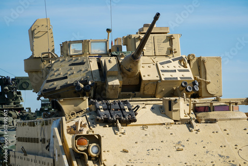 Military or army tank ready to attack and moving over a deserted battle field terrain. 