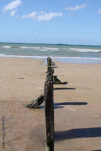pont en boit enfoncé dans le sable d'une plage