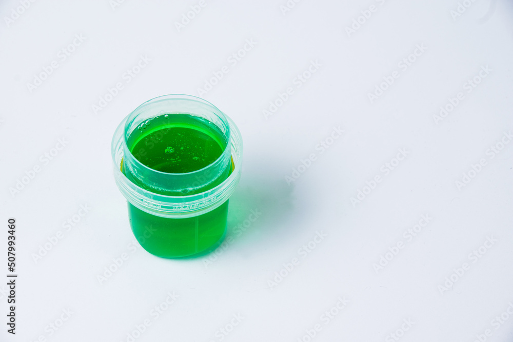 Gel for washing things in a transparent green dispenser on a white background with copy space Gel for washing things in a transparent green dispenser on a white background with copy space
