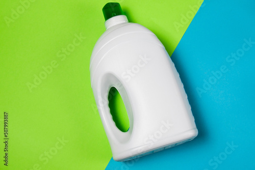 White bottle with washing gel or conditioner on a turquoise green background flatlay