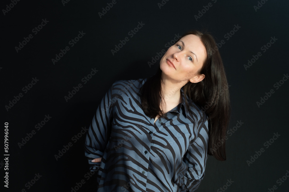 portrait of a flirtatious brunette with her hands behind her back over a black background portrait of a flirtatious brunette with her hands behind her back over a black background