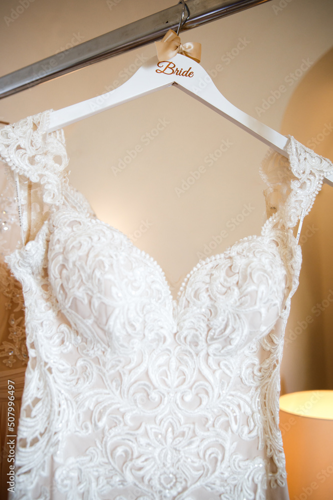 Wedding dress with lace hanging in a hotel room Wedding dress with lace hanging in a hotel room