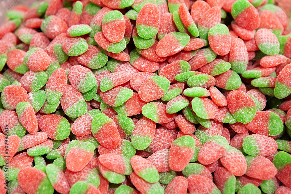 Candy sweets jelly. Close up view of delicious sweet candies in form of strawberries. Fruit jelly in shop window. Sweets for Easter, Halloween. Unhealthy or organic food. Selective focus. Top view Candy sweets jelly. Close up view of delicious sweet candies in form of strawberries. Fruit jelly in shop window. Sweets for Easter, Halloween. Unhealthy or organic food. Selective focus. Top view