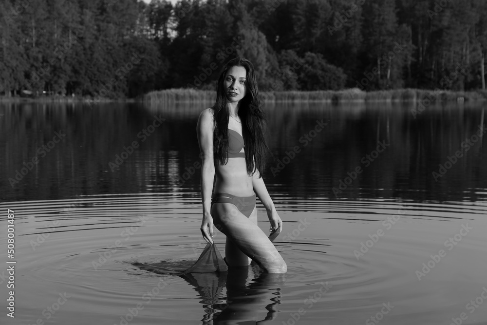 Young long-haired woman in bikini in the lake in black and white Young long-haired woman in bikini in the lake in black and white