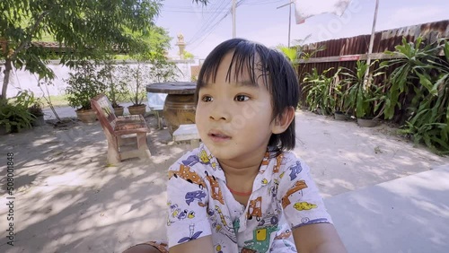 Close-up portrait of joyful happy little boy laughing and smiling in the garden