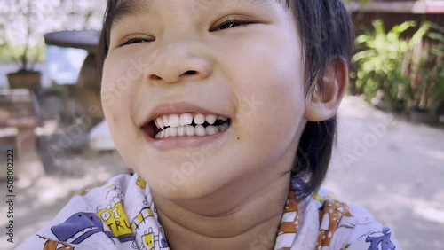 Close-up portrait of joyful happy little boy laughing and smiling in the garden