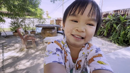 Close-up portrait of joyful happy little boy laughing and smiling in the garden
