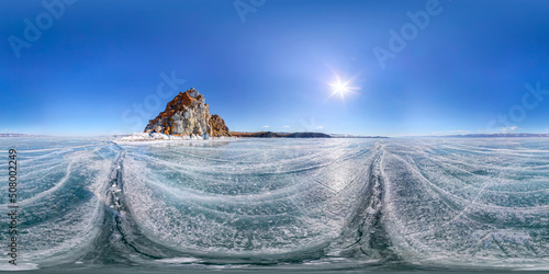 Spherical Panorama 360 degree Shaman Rock or Cape Burhan on Olkhon Island in winter, surrounded by the blue ice of Lake Baikal with cracks. photo