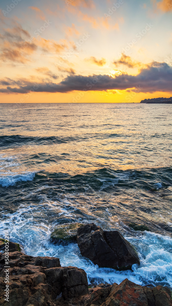 Obraz premium calm morning at the sea. nature scenery with rocky coast at dawn. clouds glowing on the sky. scenic picture-postcard view. black sea, bulgaria, europe
