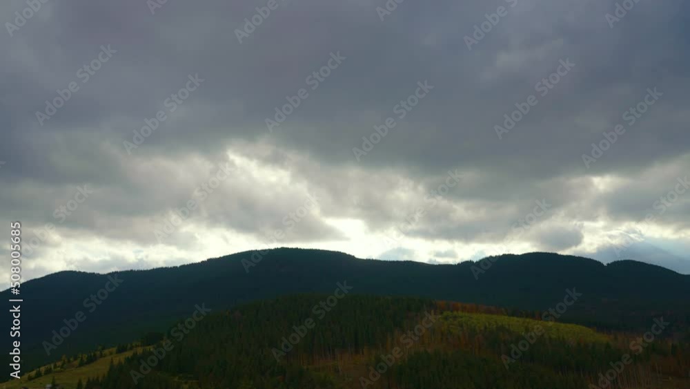 Autumn landscape of a mountain range covered with vegetation. Heavy gray clouds in the sky, through which the sun's rays break through. The concept of peace, tranquility, balance and relaxation Autumn landscape of a mountain range covered with vegetation. Heavy gray clouds in the sky, through which the sun's rays break through. The concept of peace, tranquility, balance and relaxation