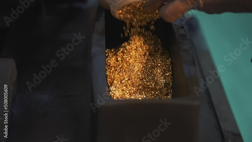 This stock video shows the process of making gold bars from precious metal granules. This video will decorate your projects. photo