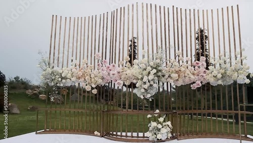 Wedding decor. Beautiful wedding arch with fresh flowers in the garden on a summer sunny beautiful wedding day