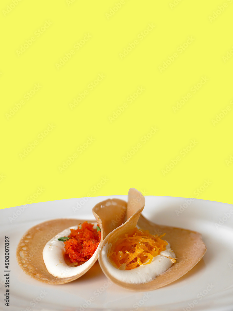 Thai Crispy pancake crepes filled with coconut cream, Thai sweetmeat, shredded coconut, strips of egg yolks, dessert on white plate, with clipping path