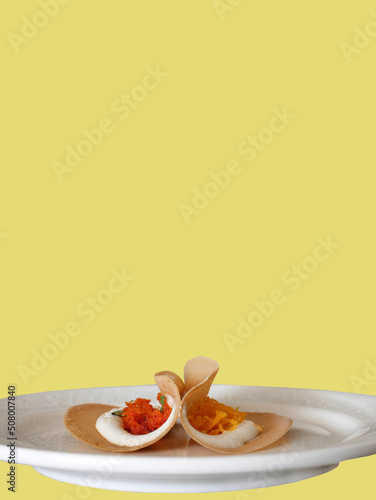 Thai Crispy pancake crepes filled with coconut cream, Thai sweetmeat, shredded coconut, strips of egg yolks, dessert on white plate, with clipping path