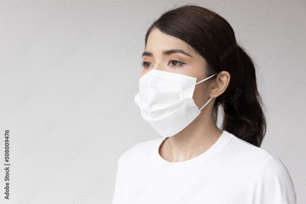 Asian woman wearing white face mask for seasonal flu and dust pollution protection Asian woman wearing white face mask for seasonal flu and dust pollution protection