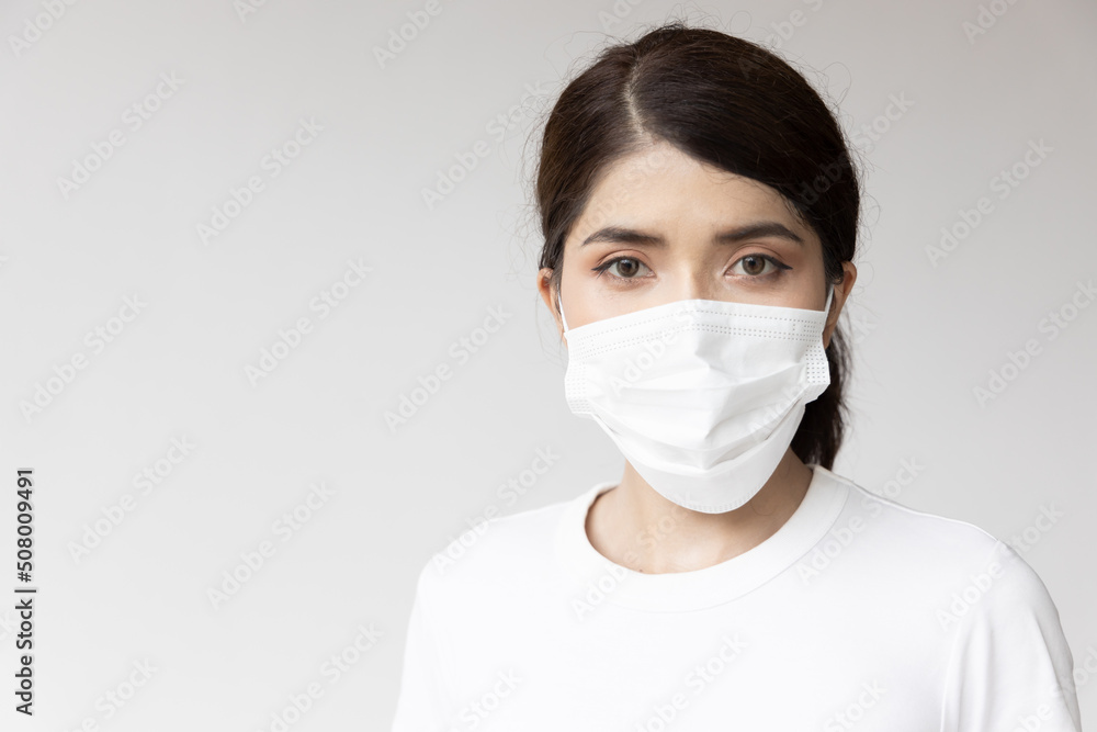 Asian woman wearing white face mask for seasonal flu and dust pollution protection Asian woman wearing white face mask for seasonal flu and dust pollution protection